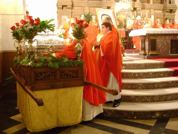 037.JPG - Varios sacerdotes cogen la urna-relicario para colocarla en su sitio definitivo.